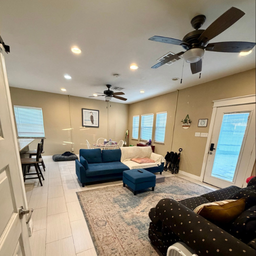 Wide living area with ceiling fans, blue sofas and French door access at 1010-B Delasandri