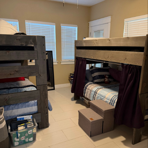 Furnished bunk bed bedroom with large windows at the Cottage at Delasandri sober living home