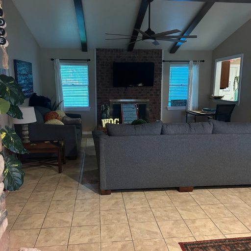 Spacious communal living room with vaulted beamed ceiling, fireplace and large TV