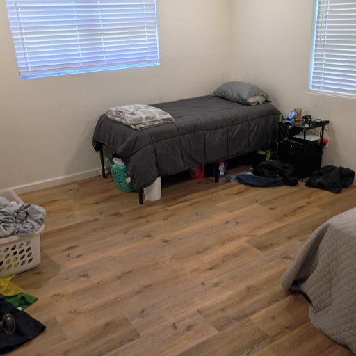 Clean bright bedroom with single beds and natural light at Idaho Drive sober living