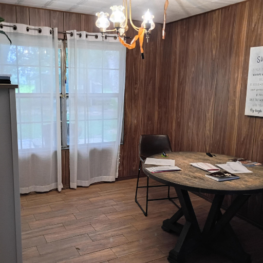 Bright dining nook with chandelier, round table, and sheer curtains at 1011 Sue Drive Kemah