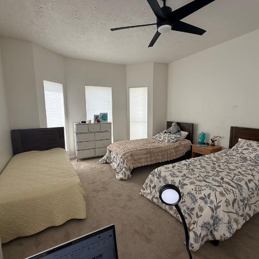 Furnished bedroom at Vantage Pointe with multiple beds and natural light